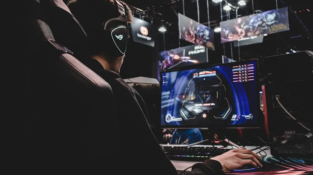 Video game development studio with composer reviewing sync licensing terms on screen